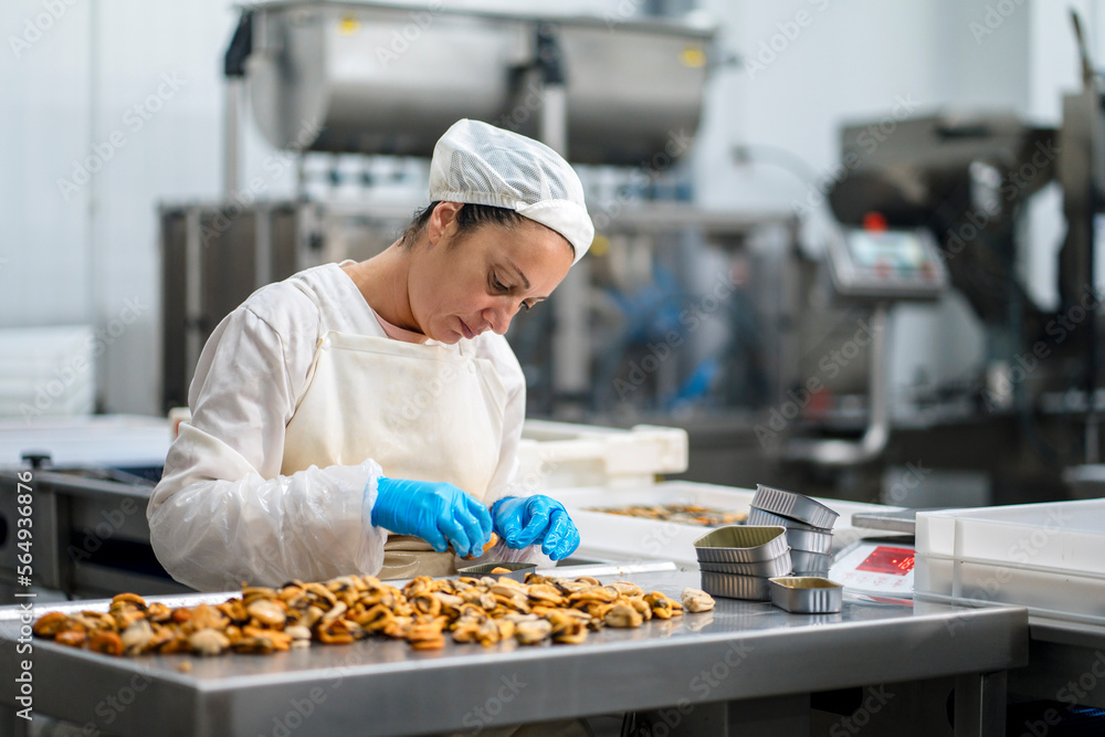 Female factory worker packaging seafood into boxes