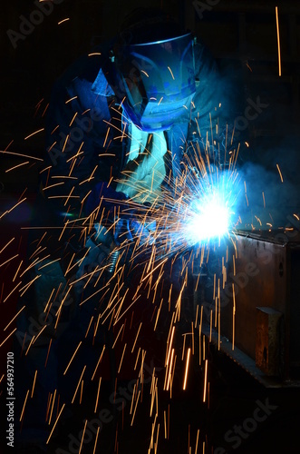Workers wearing industrial uniforms and Welded Iron Mask at Steel welding plants, industrial safety first	