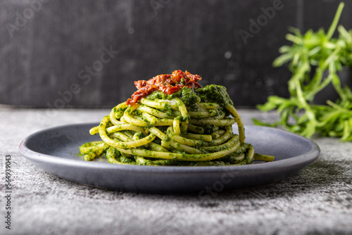 Gragnano spaghetti with homemade rocket pesto and dried tomatoes. Dish suitable for adults and children, healthy and tasty. photo