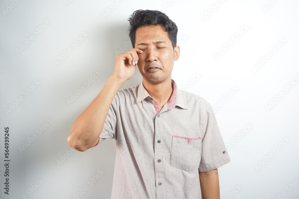 Funny asian man crying wipes tears losing his job. Funny asian man crying wipes tears losing his job.