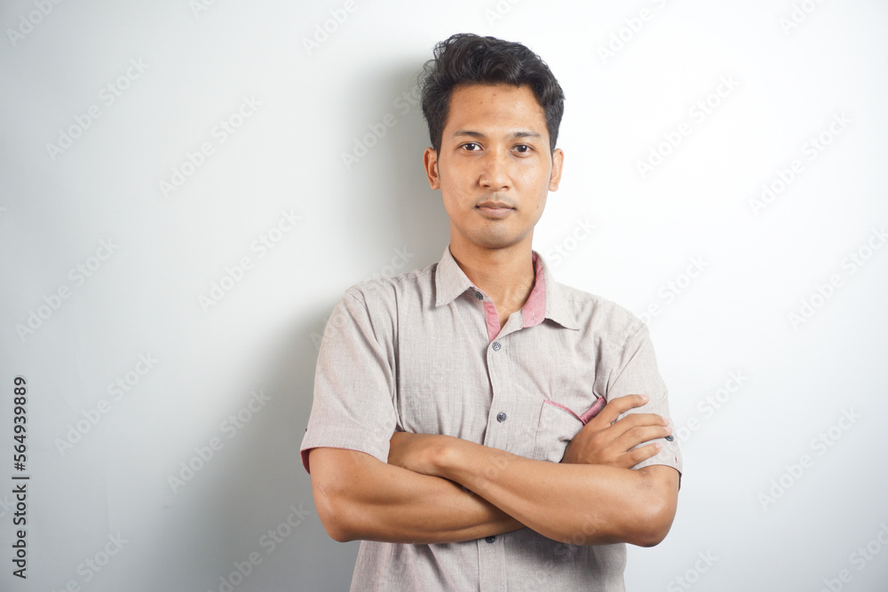 Handsome Asian young man with arms crossed over chest looking at camera Handsome Asian young man with arms crossed over chest looking at camera
