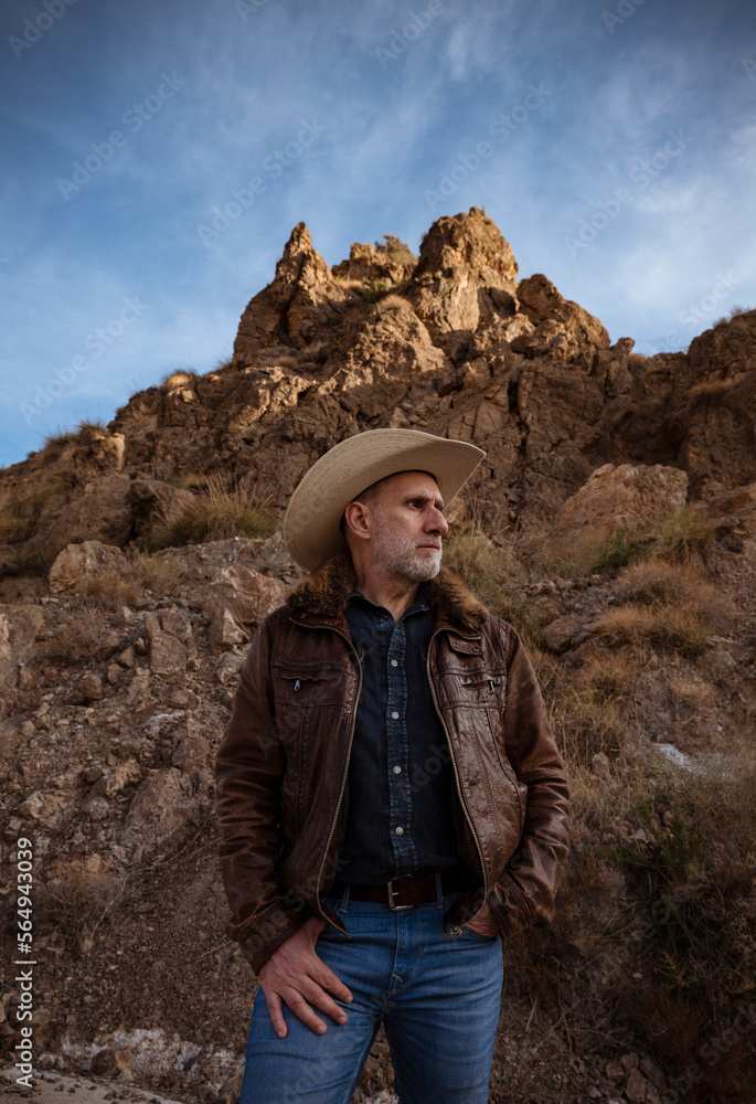Adult man in cowboy hat against mountain and sky. Almeria, Spain