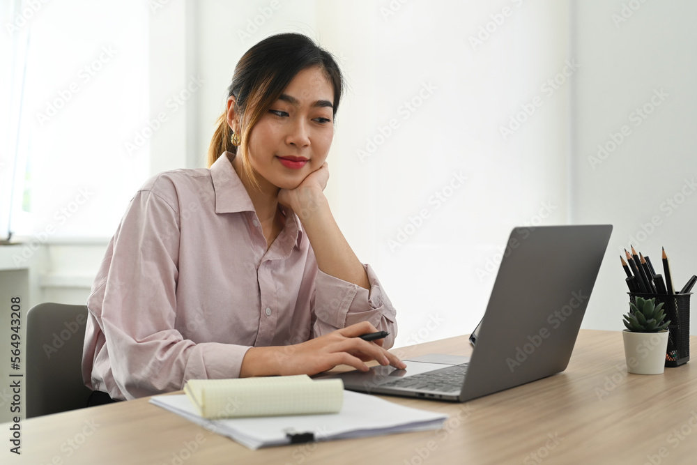 Pretty asian female executive manager typing on laptop computer, working in contemporary corporation office Pretty asian female executive manager typing on laptop computer, working in contemporary corporation office