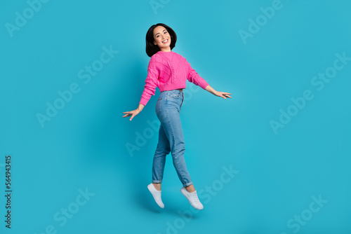 Full length photo of sweet shiny lady wear pink pullover walking jumping high isolated blue color background