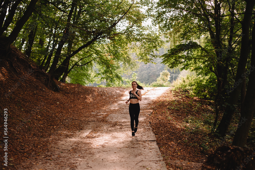 Front view of young woman running at park on sunny day Front view of young woman running at park on sunny day