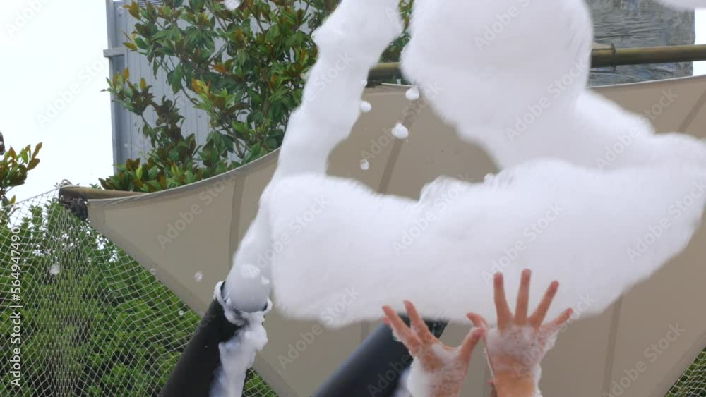 Large foam cannons shoot upwards with thick white foam at a foam party