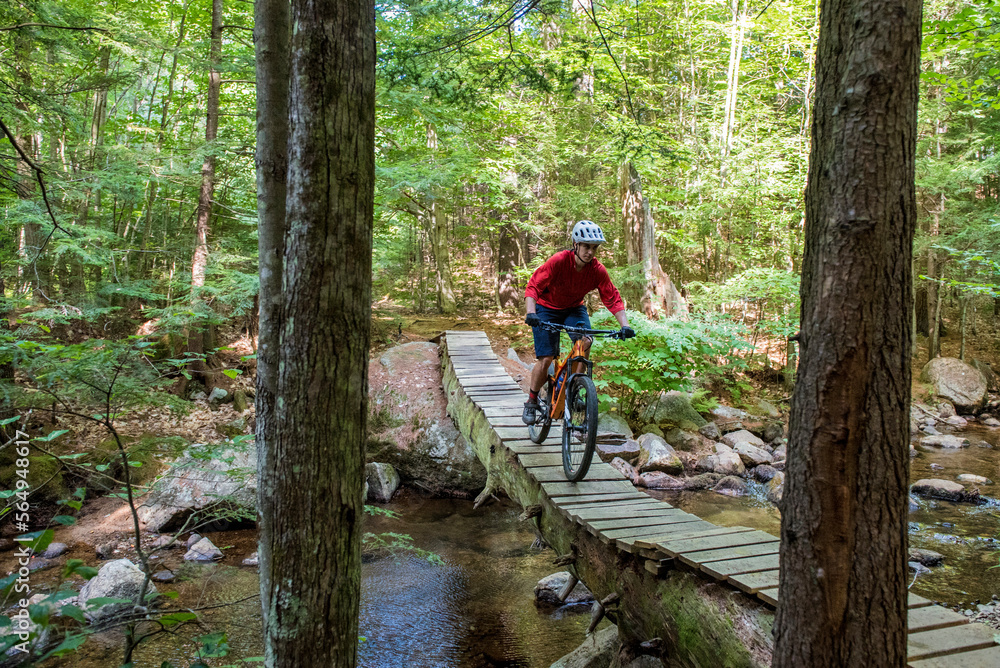 Mountain biker crossing a log bridge Mountain biker crossing a log bridge