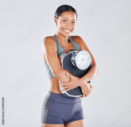 Diet  portrait and scale with a black woman athlete in studio on a gray background for body positivity or health. Fitness  weightloss and losing weight with a young female posing for wellness