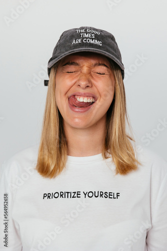 Cheerful young woman in white t-shirt standing in studio photo
