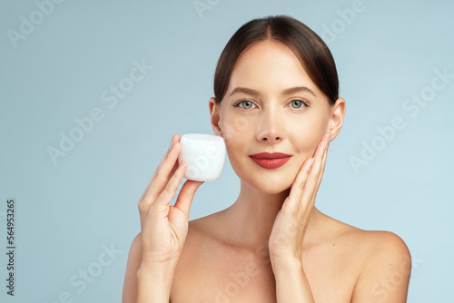 Skincare model. Beauty portrait young woman is holding a jar with cream or another type or skin care product. Mock up