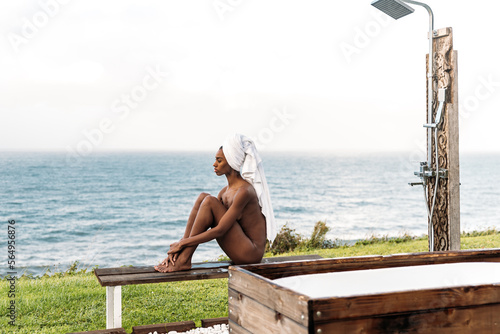 Naked black female sitting on bench