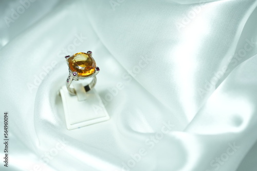 Yellow citrin Gems ring display show on white fabric satin. Luxury jewelry big head Gems