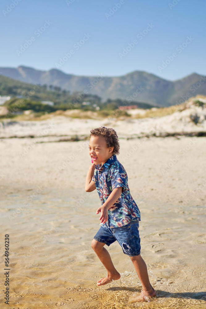 Happy boy with Down Syndrome playing on sunny beach Happy boy with Down Syndrome playing on sunny beach