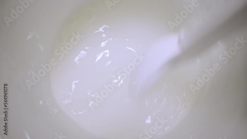 Plastic spoon used for mixing powder and water in white cup. Process of pain reliever remedy preparation to handle headache extreme closeup