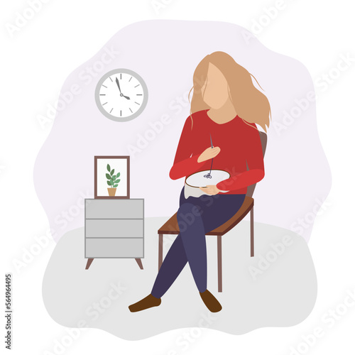 The girl sits on a chair in the room and embroiders. A needlewoman at work. Hobby and leisure