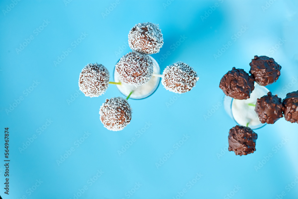 Delicious homemade popcake coconut and dark chocolate cake pops on a blue background, festival desserts, tasty food