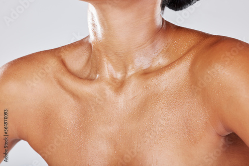 Woman neck sweating due to exercise with wet skin as water drip on a female body isolated in studio white background. Shower, model and active person chest with liquid drops due to sports