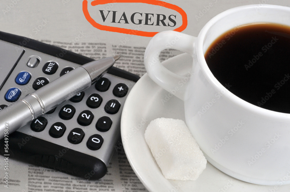 Concept de viager avec une tasse de café et une calculatrice Concept de viager avec une tasse de café et une calculatrice