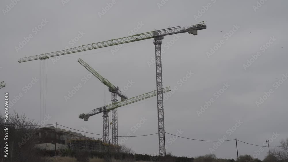 3 cranes construction time lapse. Cranes at the construction site are moving construction work. Moving clouds and an overcast evening sky in the background. A small video for advertising design. 3 cranes construction time lapse. Cranes at the construction site are moving construction work. Moving clouds and an overcast evening sky in the background. A small video for advertising design.