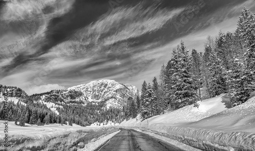 Road through a beautiful snowy valley, dolomite mountains in winter season