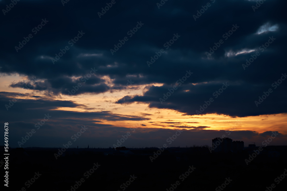 Bright sunset against the background of heavy dark clouds.