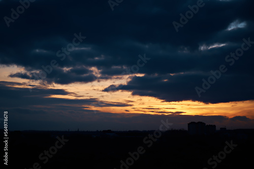 Bright sunset against the background of heavy dark clouds.