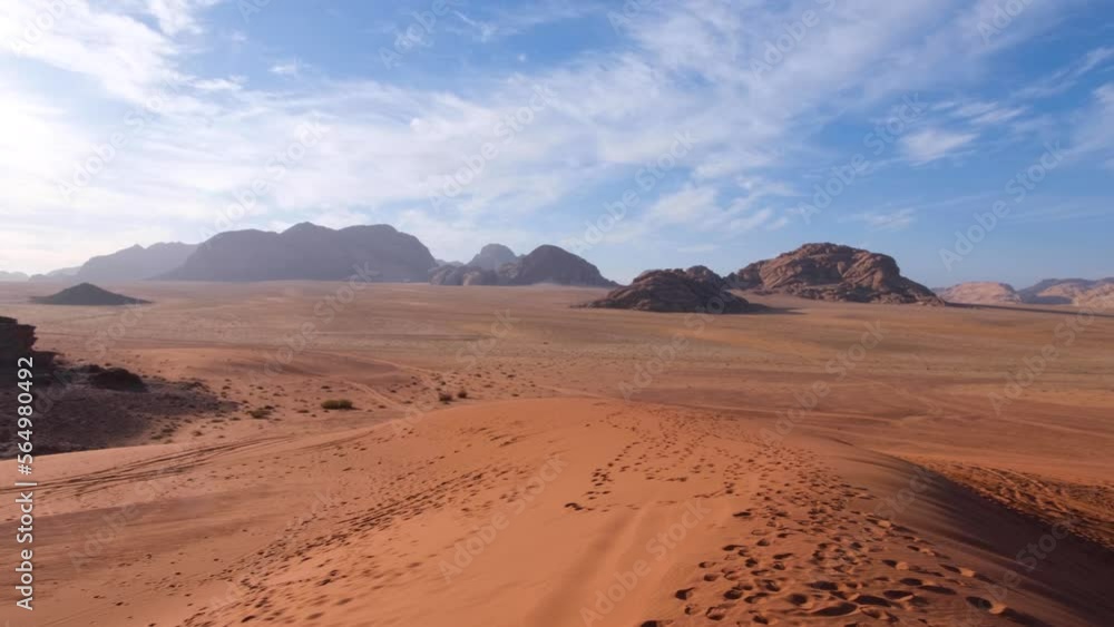 Panoramic landscape view of hostile, barren red sandy desert and mountainous terrain of Arabian Wadi Rum in Jordan, Middle East Panoramic landscape view of hostile, barren red sandy desert and mountainous terrain of Arabian Wadi Rum in Jordan, Middle East