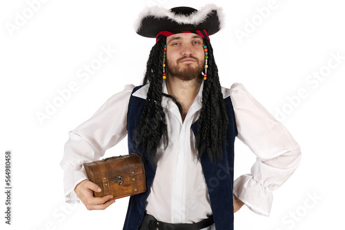 Fotografie A pirate of the Caribbean in a suit is standing stands and holds a small treasure chest