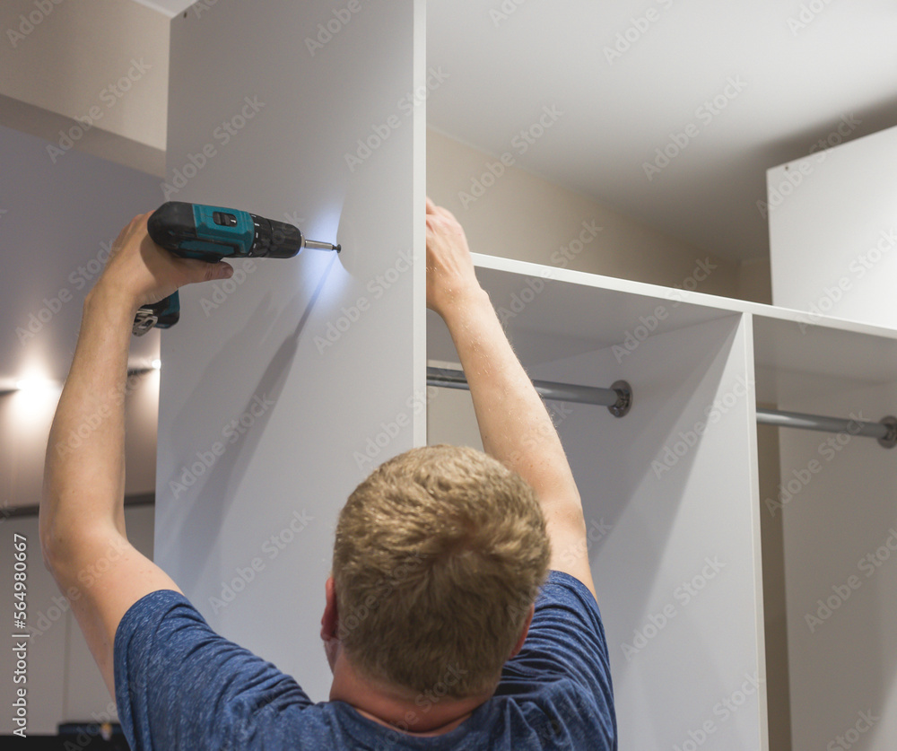 Master furniture maker assembles closet in the hallway, closeup