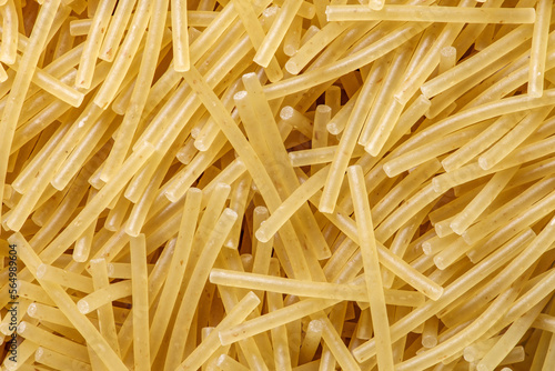 Pasta raw, vermicelli, background uniform texture, bunch in bulk close-up macro top view