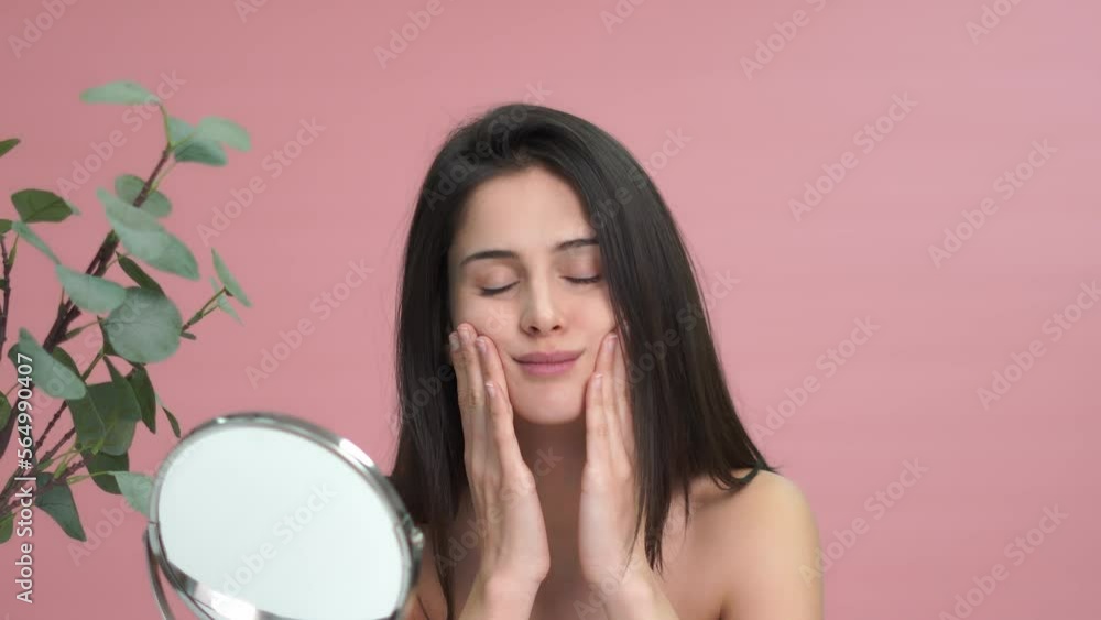 Happy woman applying cream on cheek Happy woman applying cream on cheek