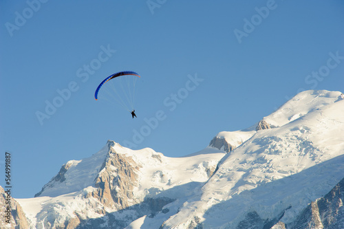 Paragliding over snow covered mountains