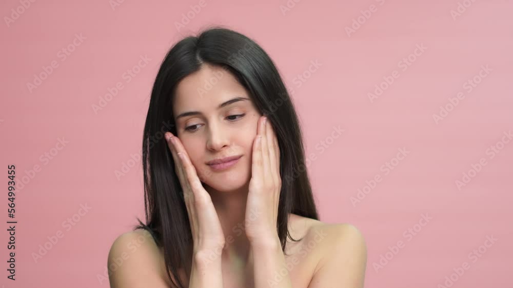 woman with makeup touching cheeks applying cream on face woman with makeup touching cheeks applying cream on face
