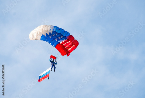 Low angle view of paraglider paragliding with Russian Flag against sky photo