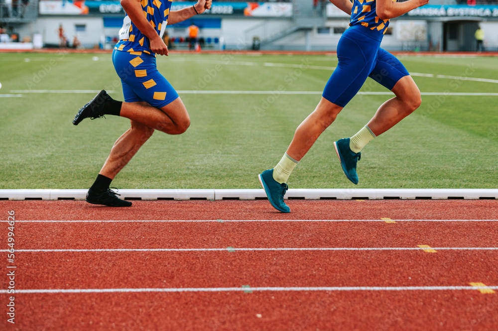 Determined male athletes legs pushing through the long distance race ...