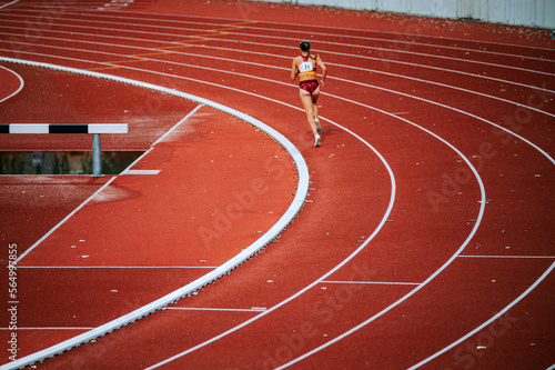 Focused female athlete pushing his limits in a distance race on track. Suitable for sports and fitness campaigns, highlighting determination and endurance