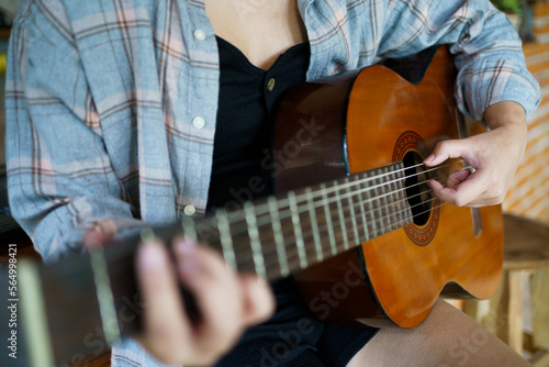 Happy young Woman hands playing acoustic guitar musician  alone compose instrumental song lesson on playing the guitar