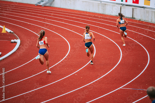 Female athletes at the starting line of a 400m race on track, showcasing their focus and determination as they prepare to compete photo