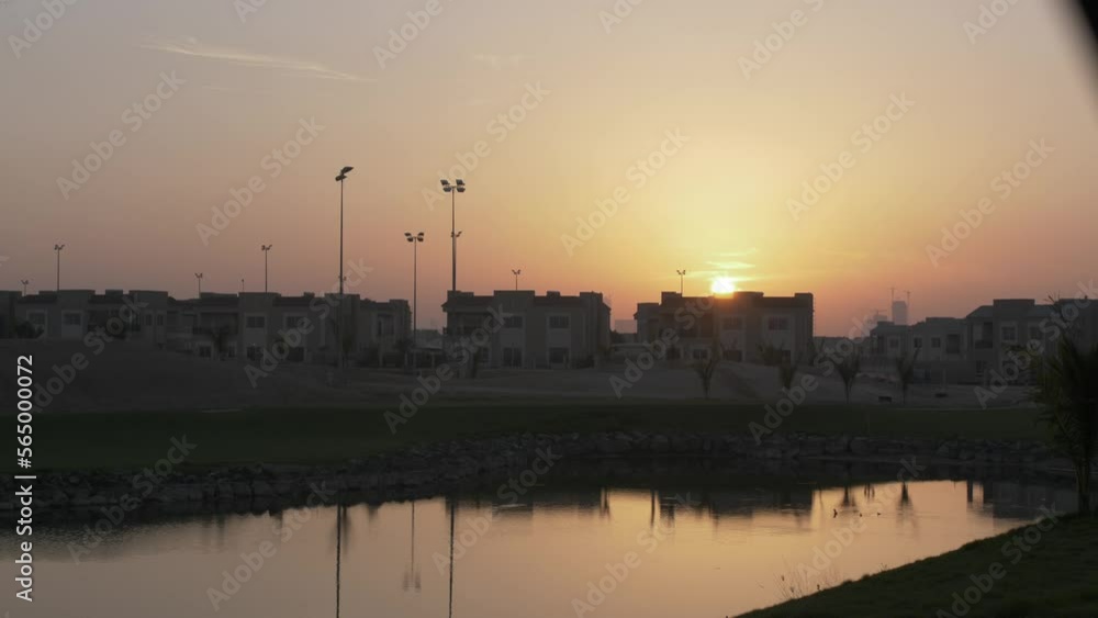 Sunset behind buildings in the evening, dusk, over homes in middle eastern city of Dubai - United Arab Emirates. Sunset behind buildings in the evening, dusk, over homes in middle eastern city of Dubai - United Arab Emirates.