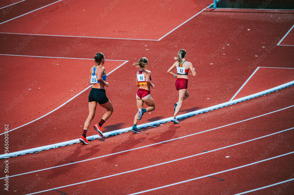 Obraz premium Determined female athletes legs pushing through the 5000m race on track, showcasing their athleticism, focus and physical fitness