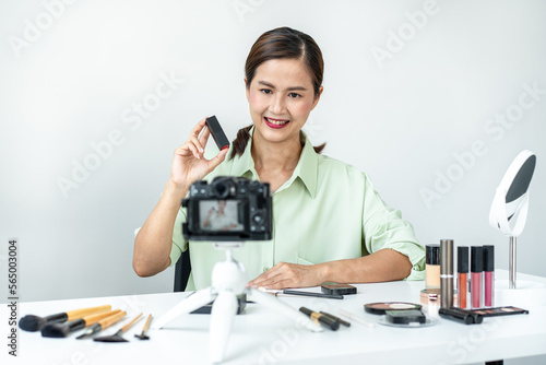 Woman blogger is present make up tutorial beauty cosmetic review product and broadcast live streaming video to teaching online on the camera screen at office studio