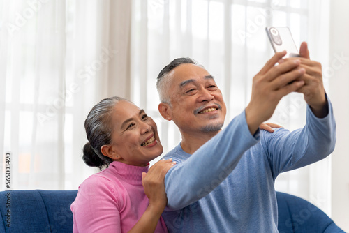 Senior couple use smartphone to selfie in living room
