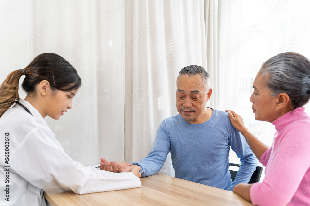 Fototapeta premium Young beautiful doctor taking senior patients pulse