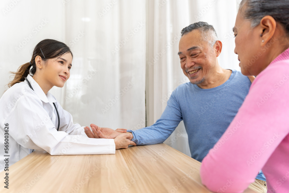 Fototapeta premium Young beautiful doctor taking senior patients pulse