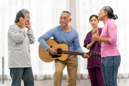 Group of senior peoples enjoy playing guitar and singing together in living room
