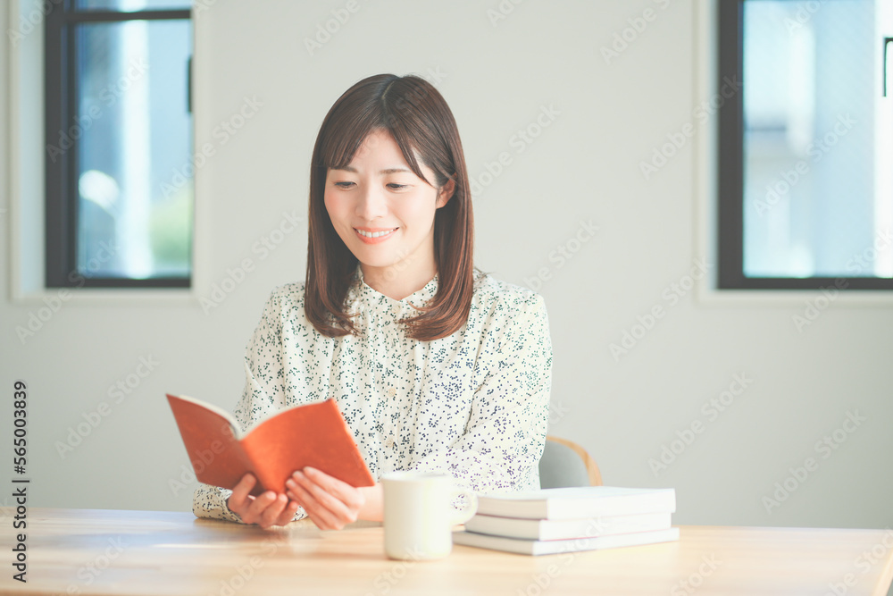 読書をしながらティータイムを楽しむ女性 読書をしながらティータイムを楽しむ女性