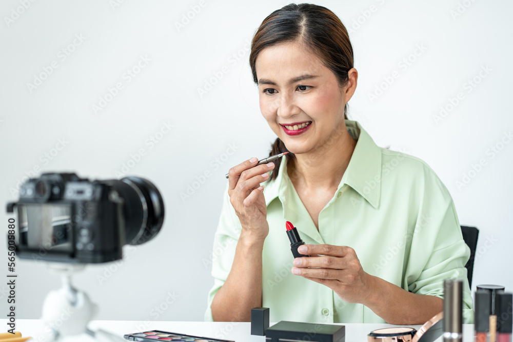 Woman blogger is present make up tutorial beauty cosmetic review product and broadcast live streaming video to teaching online on the camera screen at office studio Woman blogger is present make up tutorial beauty cosmetic review product and broadcast live streaming video to teaching online on the camera screen at office studio