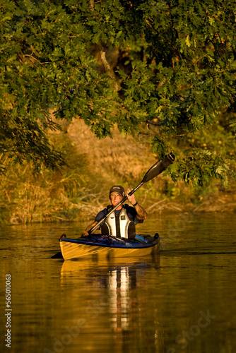 Elderly man paddling sea-kayak on small creek near Irondequoit Bay, Rochester, New York, USA. photo