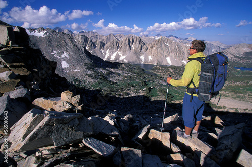 A man with backpack looking out over mountains at Kearsarge Pass, California. photo