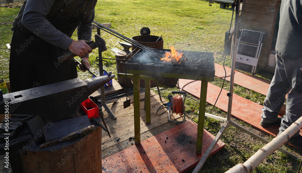 Blacksmith with red-hot iron and open charcoal fire Blacksmith with red-hot iron and open charcoal fire